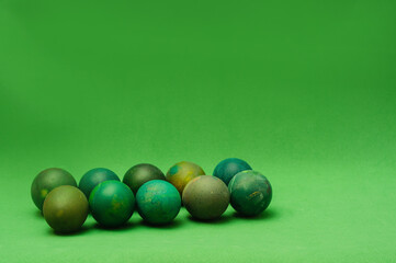 Bunch of green painted Easter eggs on green background. Monochromatic composition