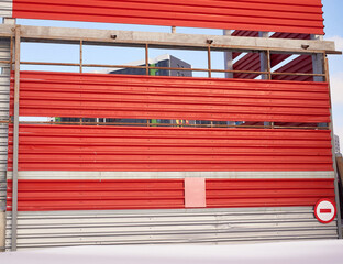 the wall of an industrial building with a sliding gate. winter view