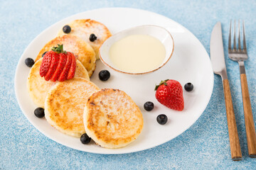 Homemade fried cheesecakes with condensed milk and berries