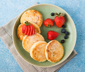 Homemade fried cheesecakes with condensed milk and berries