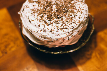Close up image of a homemade Birthday cake with whipped cream and chocolate crumbs.