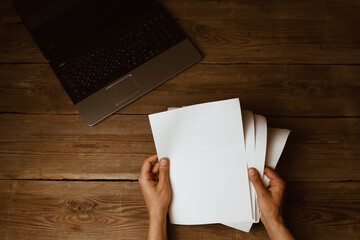 workplace blogger. set to prepare for public speaking and writing text: keyboard and phone on a wooden table, top view. freelancer typing text from paper to computer
