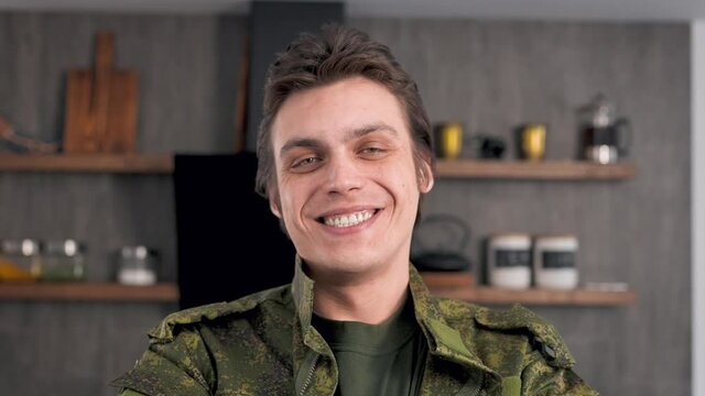 Portrait of a young soldier in army clothes. The man is happy to return home.