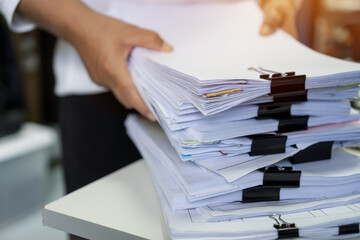 Stacks of lot documents report papers with clips waiting be managed by office workers arranging on...