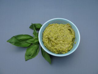 Italian green pesto sauce with basil and arugula in a bowl.