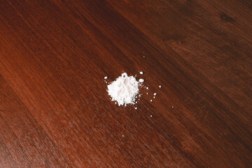 a pile of scattered cocaine on a wooden background