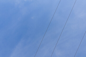 Himmel mit diagonal verlaufenden Hochspannungsleitungen