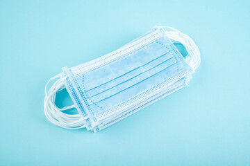 Disposable medical mask on blue background