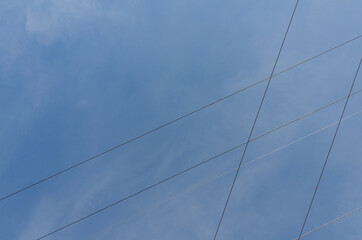 Himmel mit mehreren kreuzenden Hochspannungsleitungen