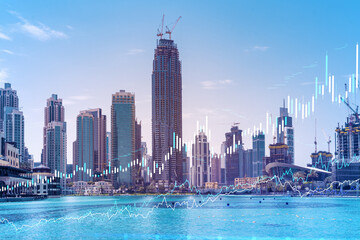 Fototapeta premium Skyscrapers of Dubai business downtown. International hub of trading and financial services of Western Asia. FOREX graph and chart concept. Double exposure. Dubai Canal waterfront.
