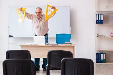 Old male geometry teacher in the classroom in pandemic concept