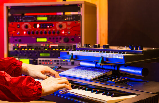 musician hands playing electric piano with soundmodule background in recording studio