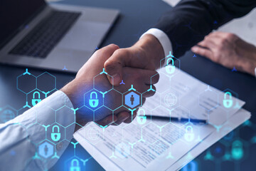 Handshake of two businessmen who enters into the contract to protect cyber security of international company. Padlock Hologram icons over the table with documents.