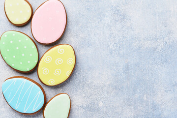 Easter multicolored gingerbread, candy and scattered confectionery topping dressing on gray background. Easter baking background. Celebratory background concept. Space for text.