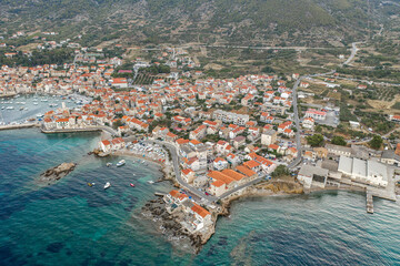 Aerial done shot of Komiza town coastline on Vis Island in Croatia before sunrise in morning