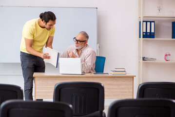 Young male student and experienced teacher in pandemic concept