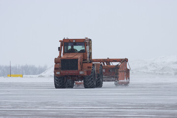 Heavy snowing at the airport and snowplow removes snow