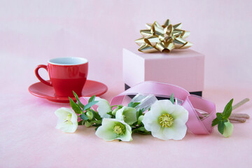 ピンクのプレゼントと赤いコーヒーカップと白いクリスマスローズ
