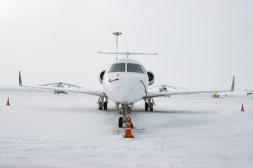Medium white airplane on the airfield in winter time