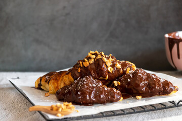 Dark chocolate croissants with nut and flower of salt on top in vintage dark stone background. Tasty and freshly croissants. 