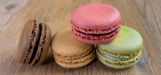 close up of fresh colorful macarons, raspberry, chocolate, hazelnut, pistachio, panorama