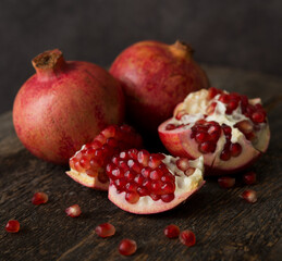 Obraz na płótnie Canvas Fresh ripe pomegranate on a wooden background, selective focus