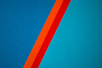 Two tone blue colored paper divided with red and orange stripes background