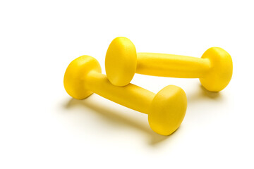 Two yellow dumbbells isolated on a white background close-up.