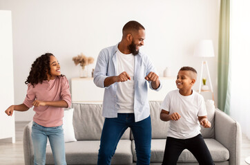 African american father dancing to music with his little children