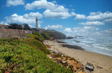 Fototapeta na wymiar Pigeon Point lighthouse against the backdrop of a beautiful sky and ocean with waves, a great landscape of the Pacific coast in California