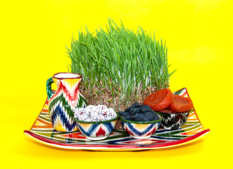 Happy background of the Navruz holiday. Celebration of Nowruz sweets and various dried fruits with green grass