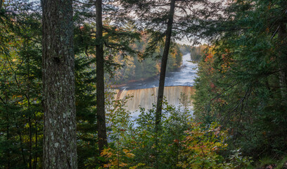 Fototapeta na wymiar Pre dawn blue hour peak through of Upper Tahquamenon Falls in Autumn - Michigan State Park in the Upper Peninsula - waterfall