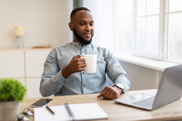 Successful Black Businessman Having Coffee Relaxing Sitting In Modern Office