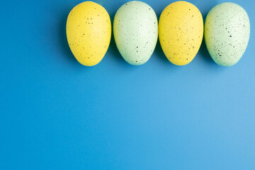 Easter eggs on a blue background, blank for design with copy space