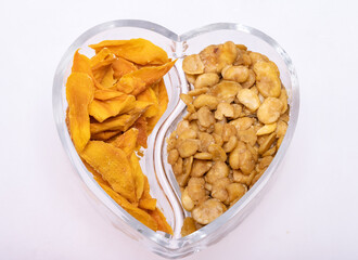 Roasted and salted fava beans and dried mango slices for a healthy vegan and vegetarian diet snack. High in protein, vitamins, dietary fibre and nutrients