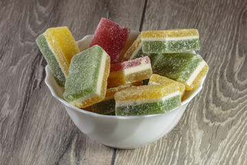 Multi colored layered marmalade in a dish. Closeup of wonderful dessert.