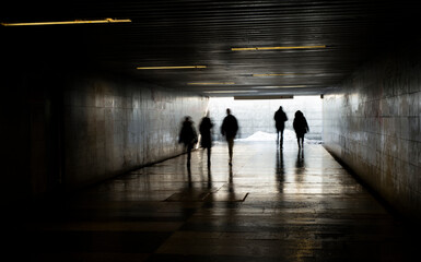 tunnel with light at the exit with people in motion