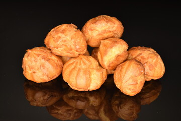 Several fresh fragrant chouquettes, on a black background.