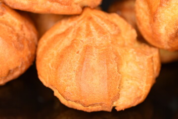 A few fragrant chouquettes on a black background.