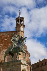 Fototapeta premium Equestrian statue of Francisco Pizarro in Plaza Mayor de Trujillo (Caceres). Work of the American sculptor Charles Casy Rumsey. In the background the Church of San Martin.