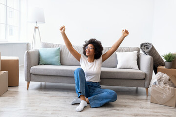 Joyful African Lady Celebrating Moving Day Sitting In New Home