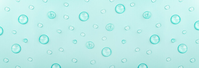 Liquid gel cosmetic on blue. Texture of drops gel on blue background. Pattern of transparent gel for face cleansing. Moisturizing cosmetic beauty product for skincare. Lotion or serum for skin care