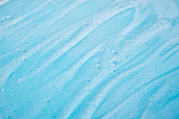 Liquid gel cosmetic on blue. Texture of liquid gel or sanitizer on blue. Pattern of transparent gel...