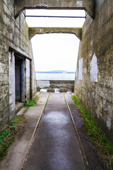 Abandoned ruins of an old costal artillery emplacement with rail road tracks leading to viewer...