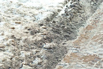 Flooded snow on the sidewalk. Early spring and melting snow. Snowy road in the city.