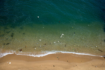 a lot of garbage floating polluted coastal beach
