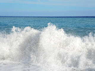 Big wave with sea foam and blue water. Beach Splashing Waves. Summer background. Foam of the sea. 