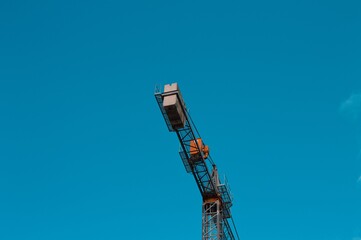 A construction crane on a construction site with clear skies in the background (Pesaro, Italy, Europe)
