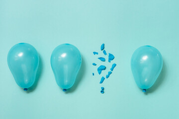 One popped balloon among other whole blue balloons on blue background. Burnout or being under...