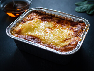 Lasagna on black wooden table
